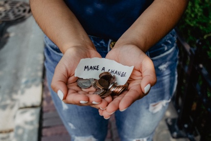hands holding spare change offering help